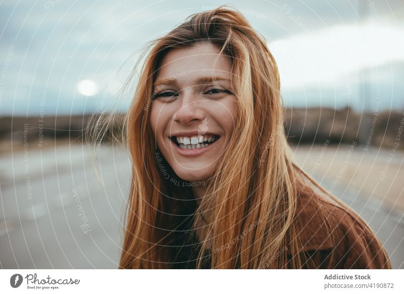 Happy lady looking at camera on street woman confident style appearance personality tranquil street style city fashion young long hair ginger hair trendy cool