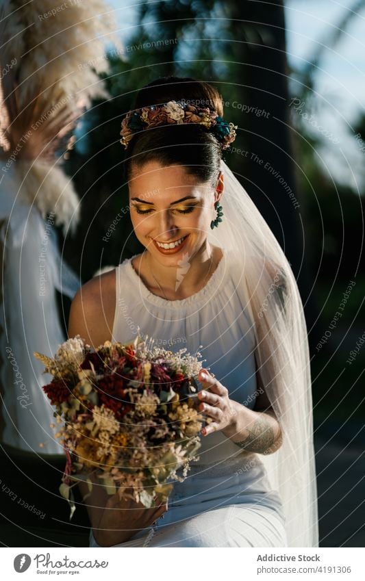 Cheerful bride with flower bouquet in garden bridal cheerful charming wedding white dress newlywed female summer fancy event elegant ceremony romantic woman