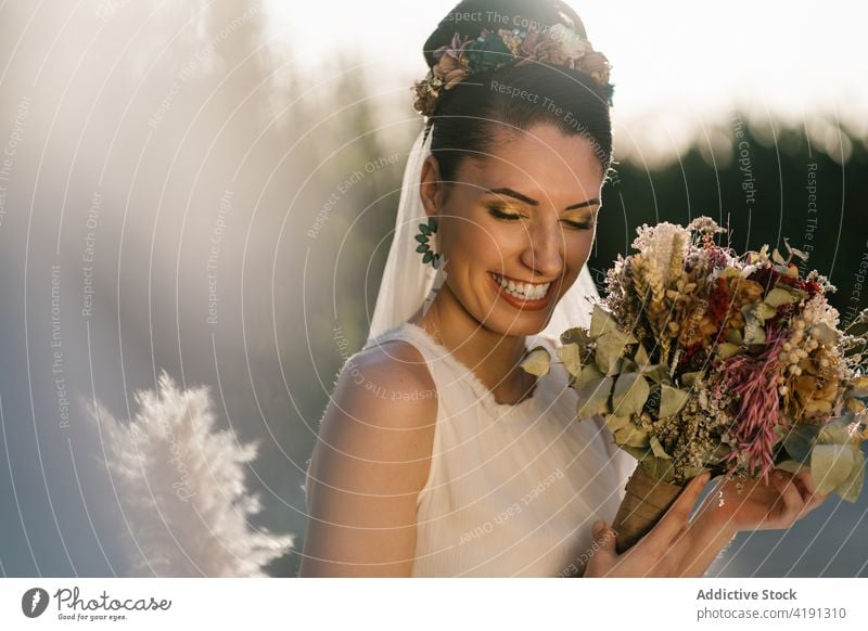 Cheerful bride with flower bouquet in garden bridal cheerful charming wedding white dress newlywed female summer fancy event elegant ceremony romantic woman