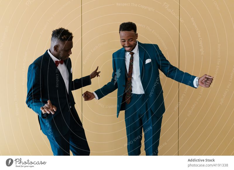 Cheerful groom and best man dancing in room dance newlywed together carefree having fun wedding suit cheerful ethnic black african american male men event