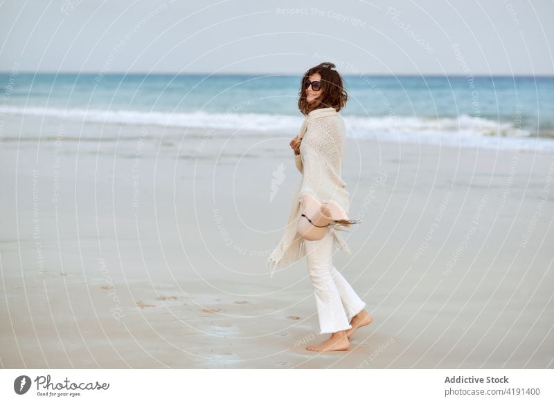 Woman on beach in summer wet seashore woman walk water cliff seaside female relax travel tourism traveler coast ocean rock nature happy vacation holiday stone