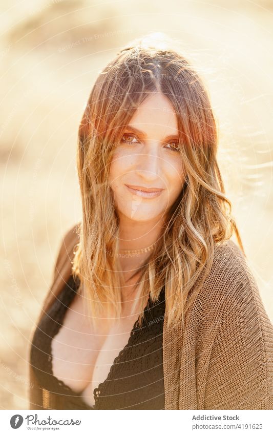 Portrait of confident woman in field portrait face style blurred background countryside nature female grass sunny trendy accessory lady harmony idyllic freedom