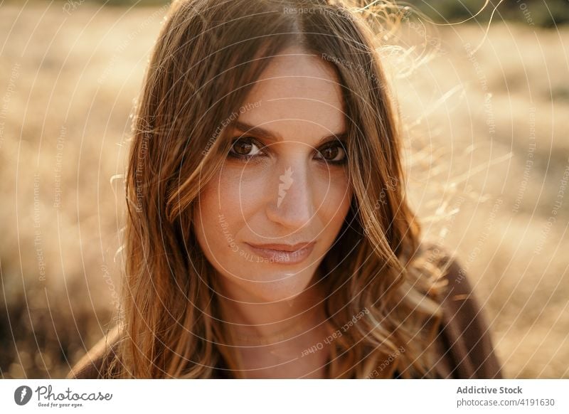 Portrait of confident woman in field portrait face style blurred background countryside nature female grass sunny trendy accessory lady harmony idyllic freedom