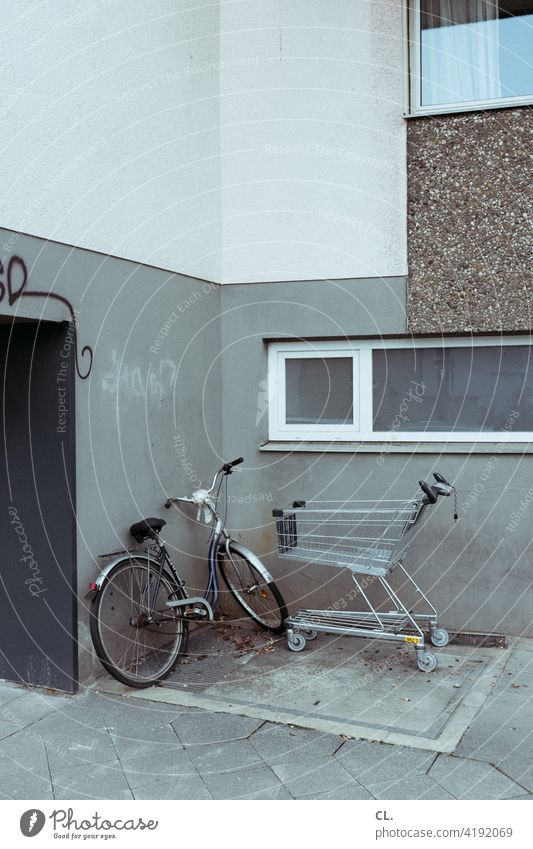 bicycle and shopping cart Bicycle Shopping Trolley Gloomy Gray House (Residential Structure) Corner Wall (building) dreariness Hideous Dirty Window bleak