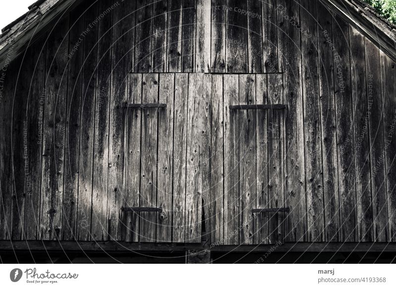 Old, weathered roof gable of a shed with closed gate. Weathered Change Transience Decline locked naturally Hut Idyll Structures and shapes Loneliness