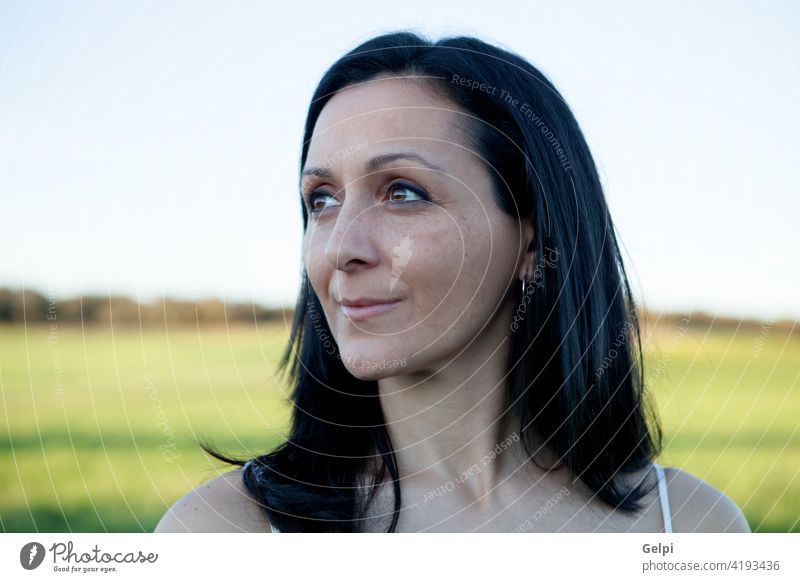 Woman looking at side relaxing on a meadow girl park beautiful spring pensive think thought sun sunny summer sunlight nature outdoor person female face woman