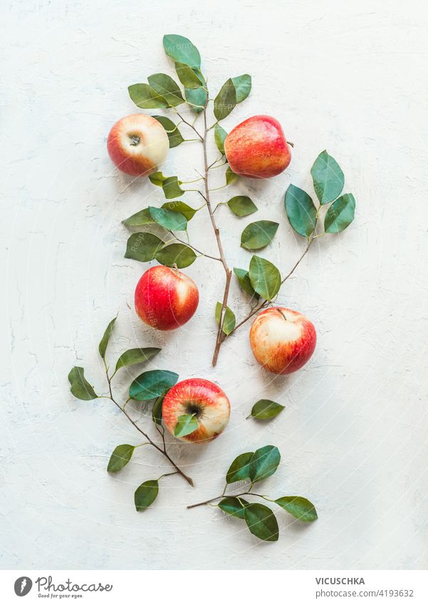 Composition of fresh red apples with green leaves on white desk background. Top view. Flat lay composition top view flat lay branch ingredient group leaf food