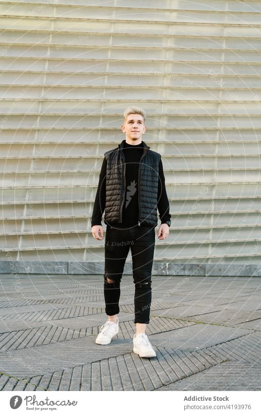 Serious young stylish guy standing near shabby wall on street man self assured serious city urban confident trendy charismatic pavement millennial relax male