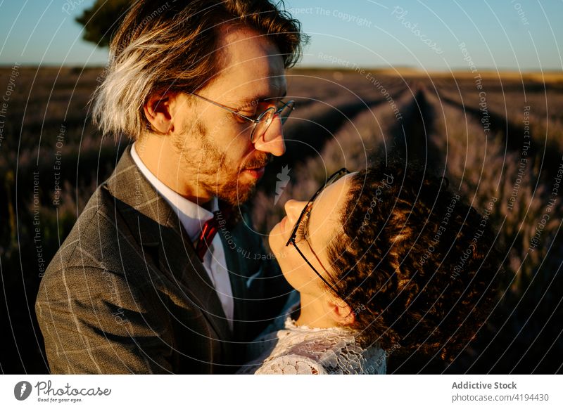 Newlyweds standing close on field at dusk couple newlywed sunset romantic nature valentine face to face occasion affection relationship love peaceful