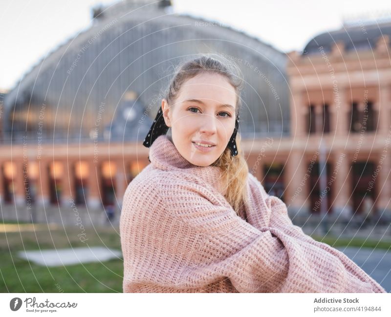 Happy young female millennial standing on street woman smile enjoy square city relax glad teenage long hair wavy hair sweater delight optimist trendy positive