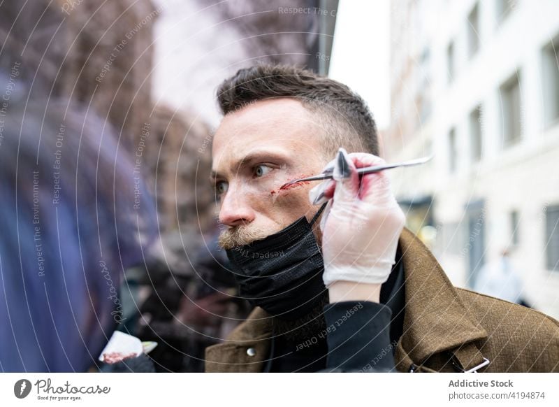 Anonymous makeup artist putting makeup on the face of a hipster man make up beard bearded fashion young male portrait guy caucasian beauty attractive hair