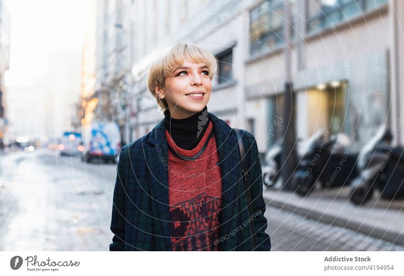 Young stylish woman standing on winter city street style snowy cool outfit positive trendy season content weather optimist madrid spain warm clothes