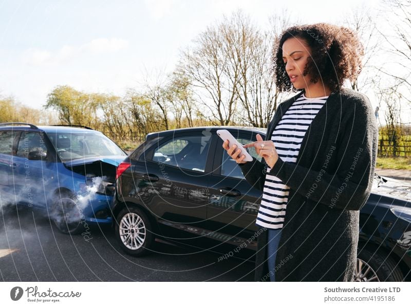 Female Driver Contacting Car Insurance Company On Mobile Phone After Road Traffic Accident woman driver car accident wreck crash insurance claim calling