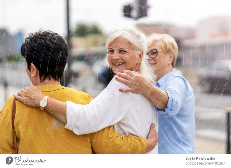 Senior female friends having good time together senior woman people retired retirement grandmother leisure standing confident attractive urban city street