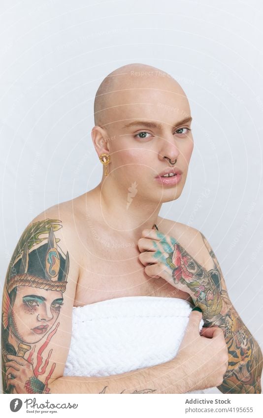 Feminine transgender man in towel on white background gay feminine tattoo lgbt gentle sensitive self regard tender dreamy portrait beauty natural accept