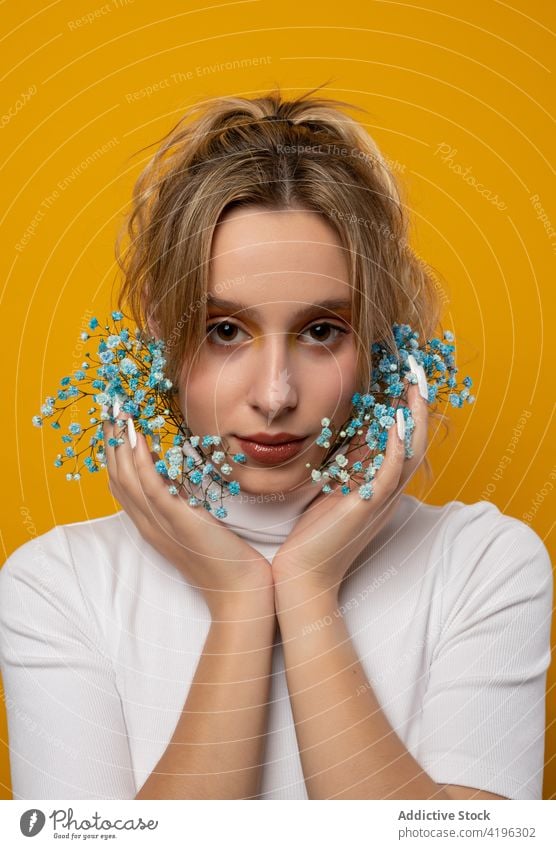 Beautiful woman with blue gypsophila flowers in studio style tender charming touching face blossom gorgeous sensitive beautiful young attractive pretty flora