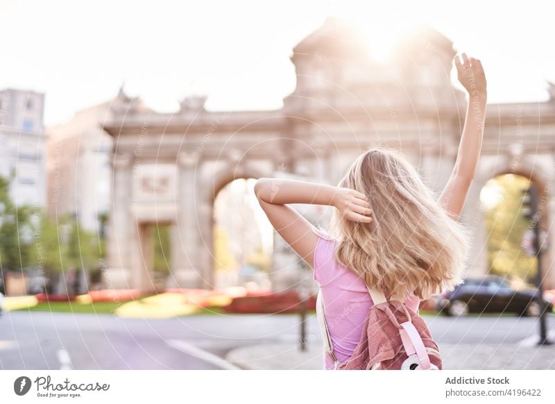 Joyful young woman enjoying vacation on city street happy teenage holiday travel fun carefree pleasure female cheerful sunshine arms raised optimist