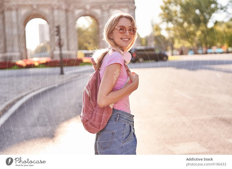 Joyful young woman enjoying vacation on city street happy teenage headphones holiday travel fun carefree pleasure cheerful sunshine optimist lifestyle smile