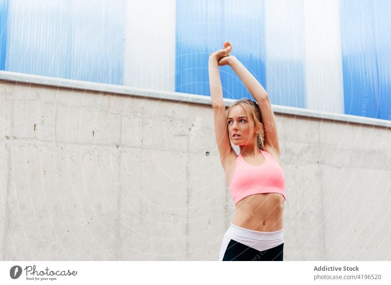 Sportswoman doing stretching on the street attractive strong workout caucasian preparation fit energy jogger outdoors stamina building practice running activity