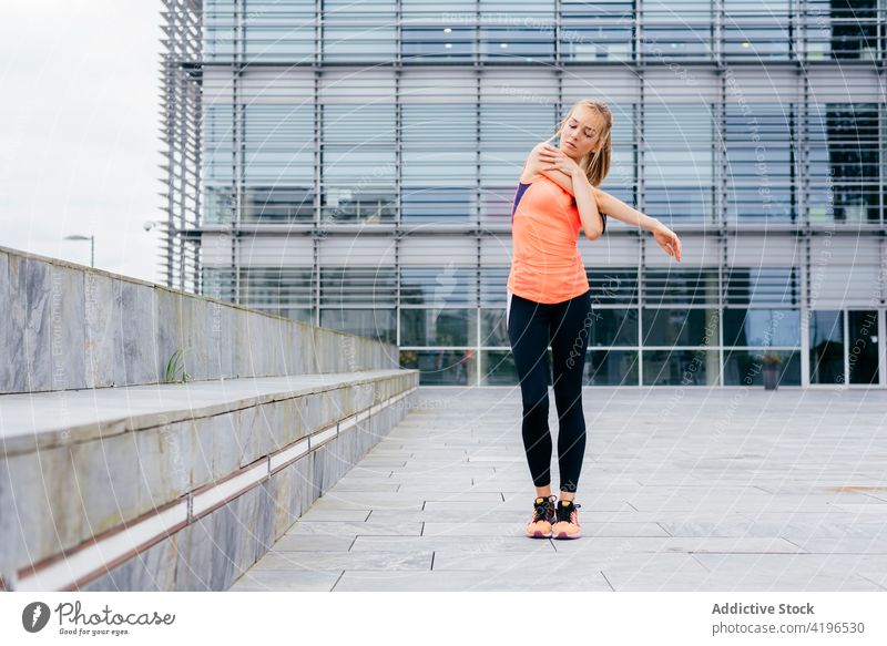 Sportswoman doing stretching on the street attractive strong workout caucasian fit energy jogger outdoors stamina full body building running activity city