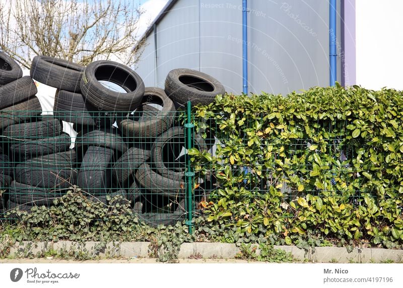 Old tires pile up in a yard Tire tire stacks Fence Ivy Hall Warehouse Building Storage Depot Work and employment Recycling Trash Disposal Rubber Material