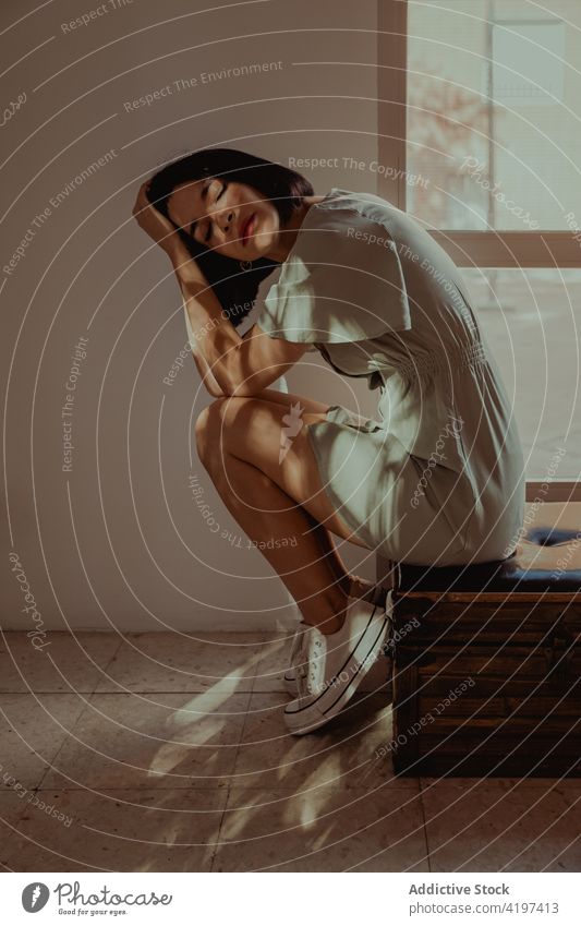 Gentle woman sitting on leather stool gentle home sunlight delicate feminine dreamy calm tender slender female peaceful room charming serene tranquil shade