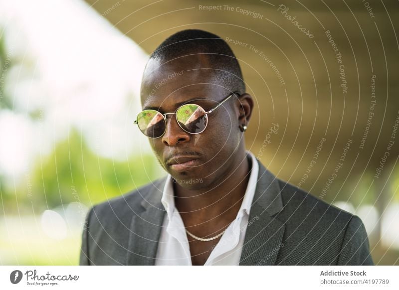 Stylish masculine black businessman in modern sunglasses fashion style individuality macho independent formal cool portrait accessory african american ethnic