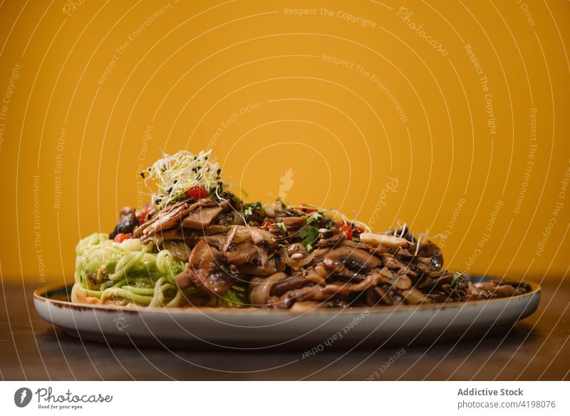 Tasty zucchini nest with assorted mushrooms on plate asian food vegetarian meal dinner menu lunch spaghetti sauteed sweet potato alioli alfalfa sprout red berry