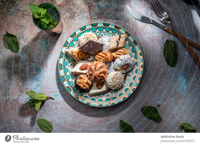 Traditional Middle East sweets with tea in restaurant baklava biscuit baked moroccan peppermint tea knife fork middle east different dessert delicious tasty