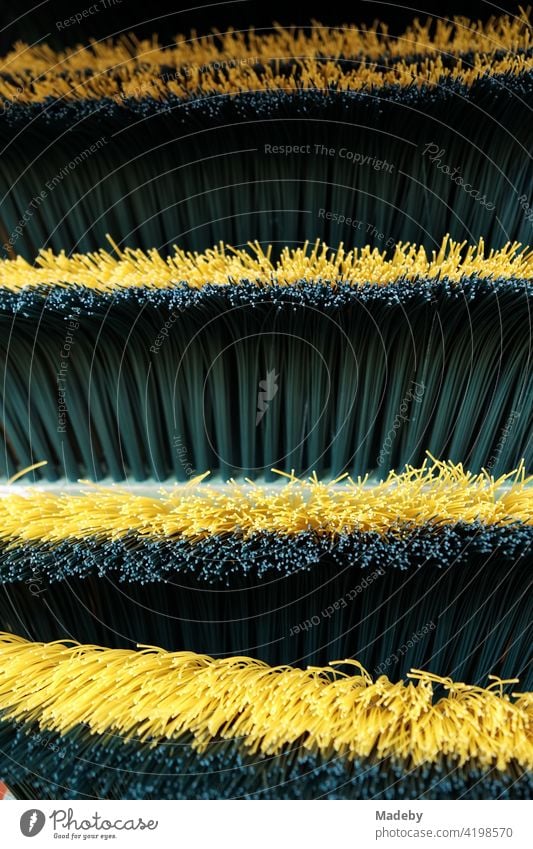 Broom with bristles made of plastic in green and yellow at the weekly market in Paderborn in East Westphalia-Lippe Bristles Sweep Yellow Green Cleaning sweeper