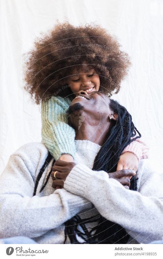 Loving daughter gently embracing cheerful father embrace gentle bonding close glad love caress girl dad man dreadlocks child afro enjoy parenthood fatherhood