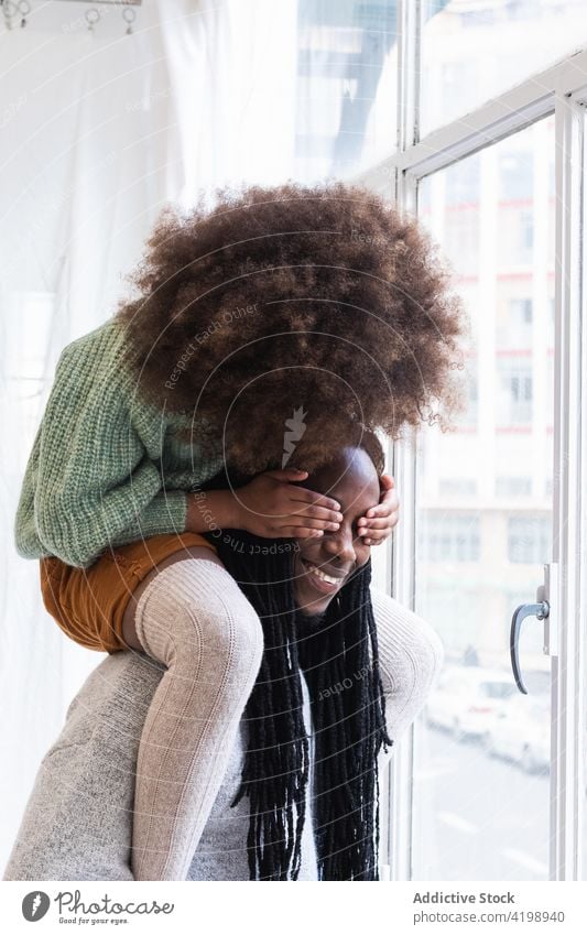 Black girl playing game with father and laughing happily daughter having fun peekaboo childhood hide together dad man hide and seek cheerful kid happy