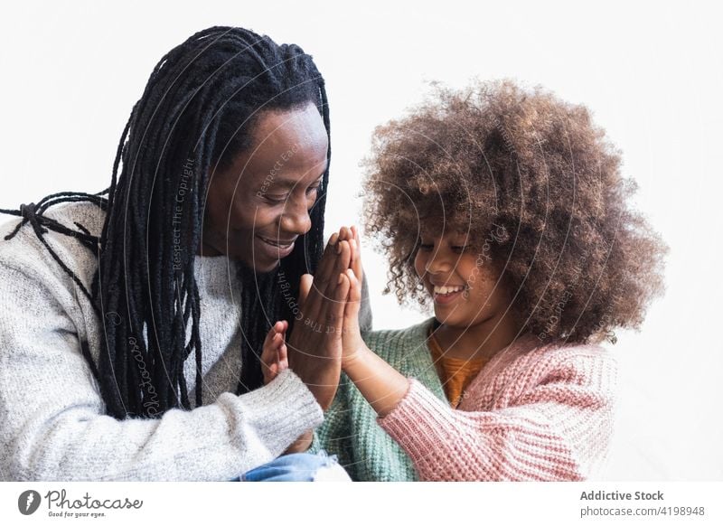 Delighted black man cuddling with daughter father cheerful cuddle caress pleasant carefree bonding enjoy together girl dad kid smile child love relationship