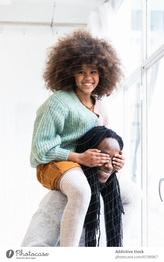 Black girl playing game with father and laughing happily daughter having fun peekaboo childhood hide together dad man hide and seek cheerful kid happy