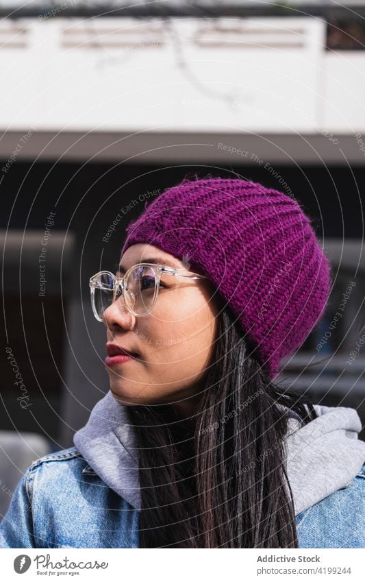 Asian brunette woman with long hair leaning on the wall and looking away japanese asian young female model chinese style attractive lady street modern stylish