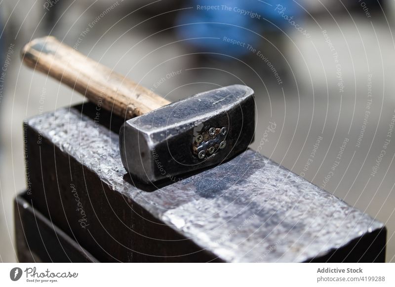 Hammer on workbench in blacksmith workshop hammer forge steel instrument heavy craftsmanship metalwork job shabby iron equipment professional workplace industry