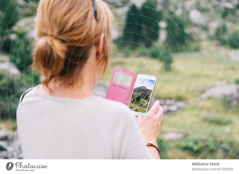 Unrecognizable woman taking photo of scenic mountainous terrain take photo highland smartphone mountaineer travel memory photography amazing verdant ruda valley