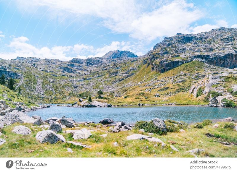 Breathtaking scenery of rippling lake surrounded by rocky mountains nature breathtaking landscape summer range pond highland majestic scenic ridge calm rough