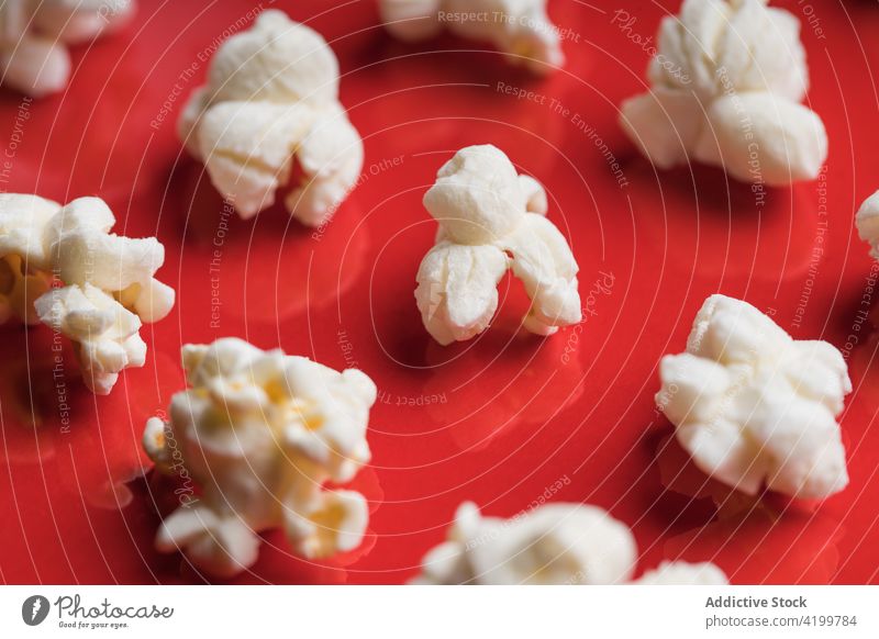 Closeup of some popcorn on a red background top view from above food snack delicious salty white tasty healthy fresh closeup entertainment sweet classic