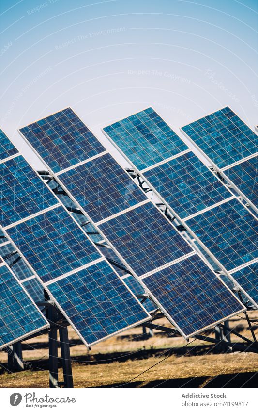 Solar panels against cloudy sky solar power station reflecting photovoltaic cloudless sunny field cells daytime energy electricity technology shiny weather