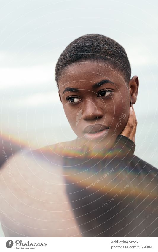 Dreamy black woman touching cheek under cloudy sky touch face dreamy short hair enjoy feminine gentle romantic portrait reflective mindful tender sincere