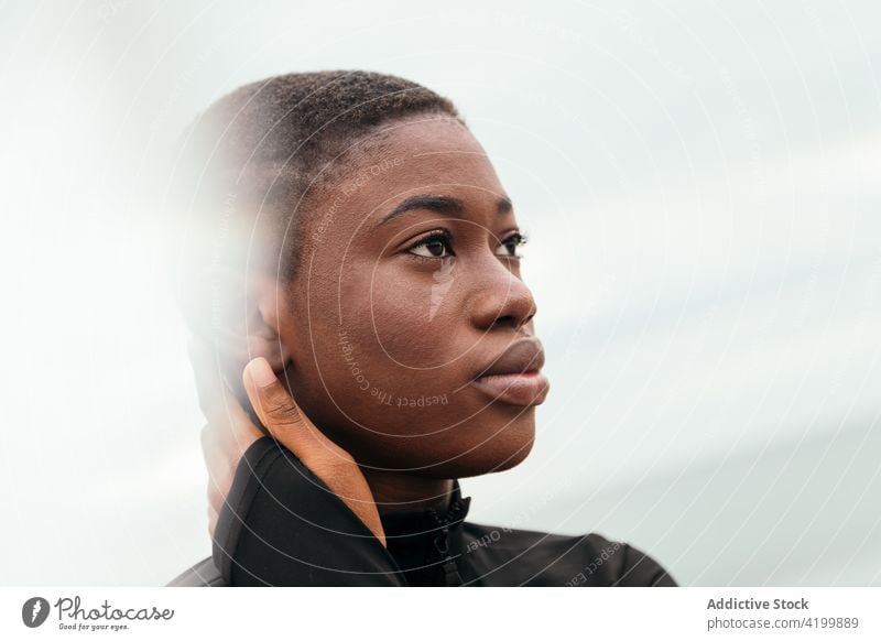 Dreamy black woman touching cheek under cloudy sky touch face dreamy short hair enjoy feminine gentle romantic portrait reflective mindful tender sincere