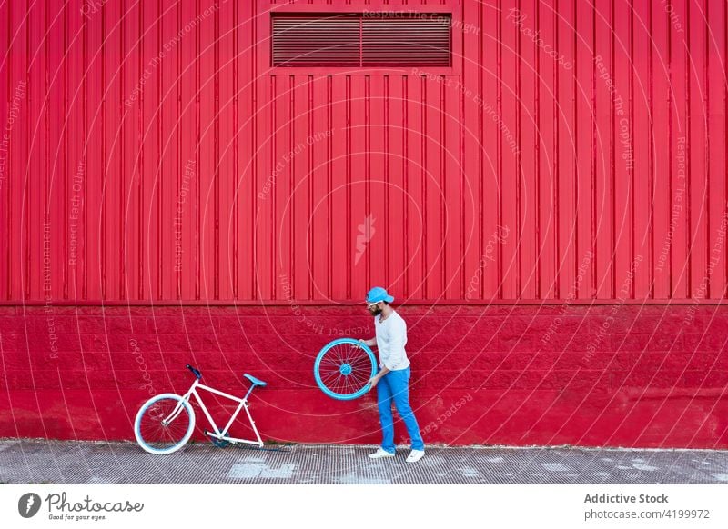 Man repairing bicycle on the street man rider cyclist city male masculine hobby modern bike casual urban town hipster pavement contemporary transport vehicle