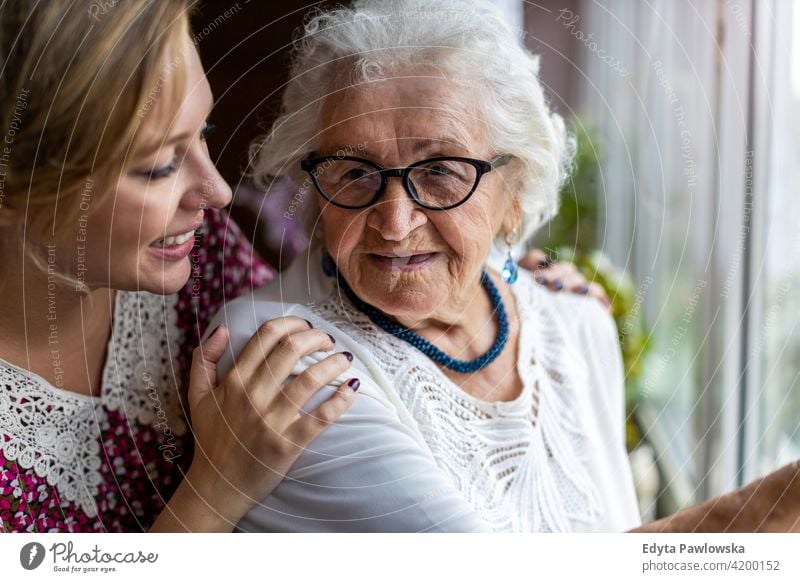 Young woman spending time with her elderly grandmother at home people senior mature casual female Caucasian house old aging domestic life pensioner grandparent