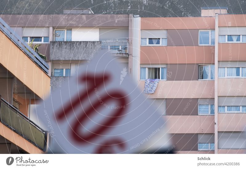 Cheap housing 10 euro sign in front of a block of flats with balconies living space price Euro Clue shallow depth of field Price tag Balconies