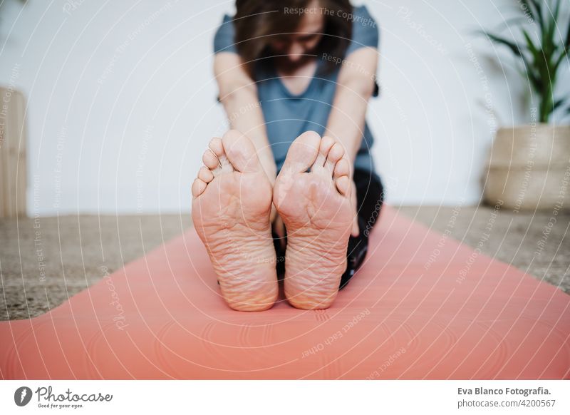 close up of mature caucasian senior woman practicing yoga pose at home. Healthy lifestyle. Focus on feet sport healthy floor old active pensioner gym elderly