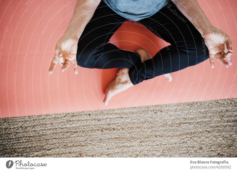 top view of mature caucasian senior woman practicing yoga at home on yoga mat. Healthy lifestyle sport healthy floor old active pensioner gym elderly female