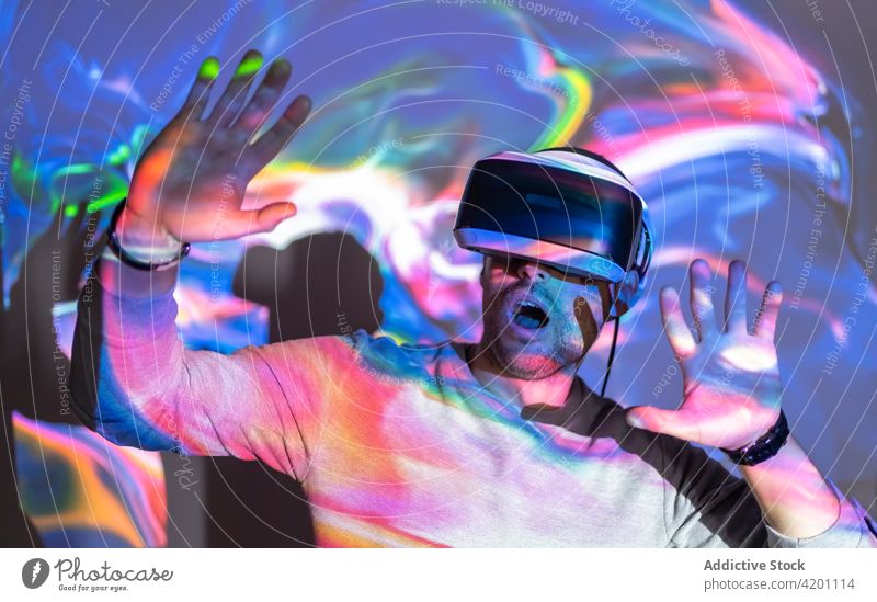 Man in VR goggles exploring virtual reality man vr headset touch experience explore illuminate projector technology innovation gadget entertain digital glasses