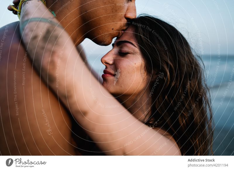 Unrecognizable black tourist kissing happy beloved against sea boyfriend girlfriend relationship sincere romantic honeymoon travel embrace eyes closed enjoy