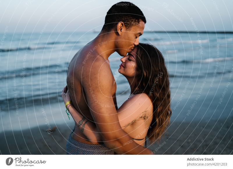 Young black tourist kissing happy beloved against sea boyfriend girlfriend relationship sincere romantic honeymoon travel embrace eyes closed enjoy pleasure hug